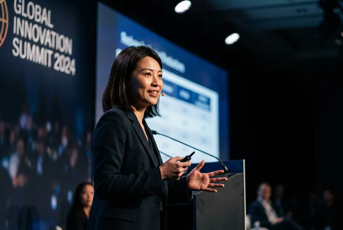 Generated image of Maya Chen presenting at a conference